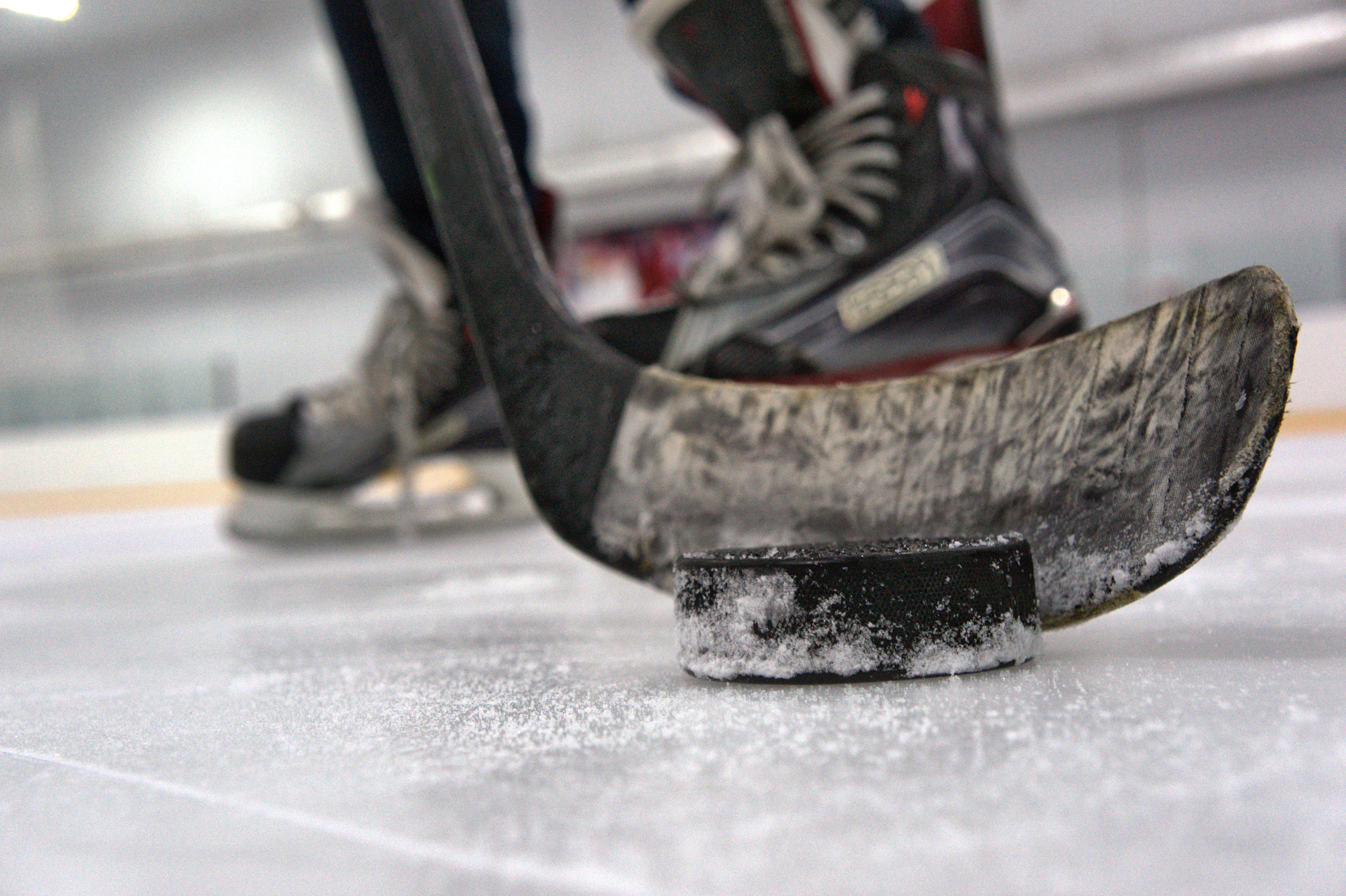 a players stick ready to launch a hockey puck across the ice