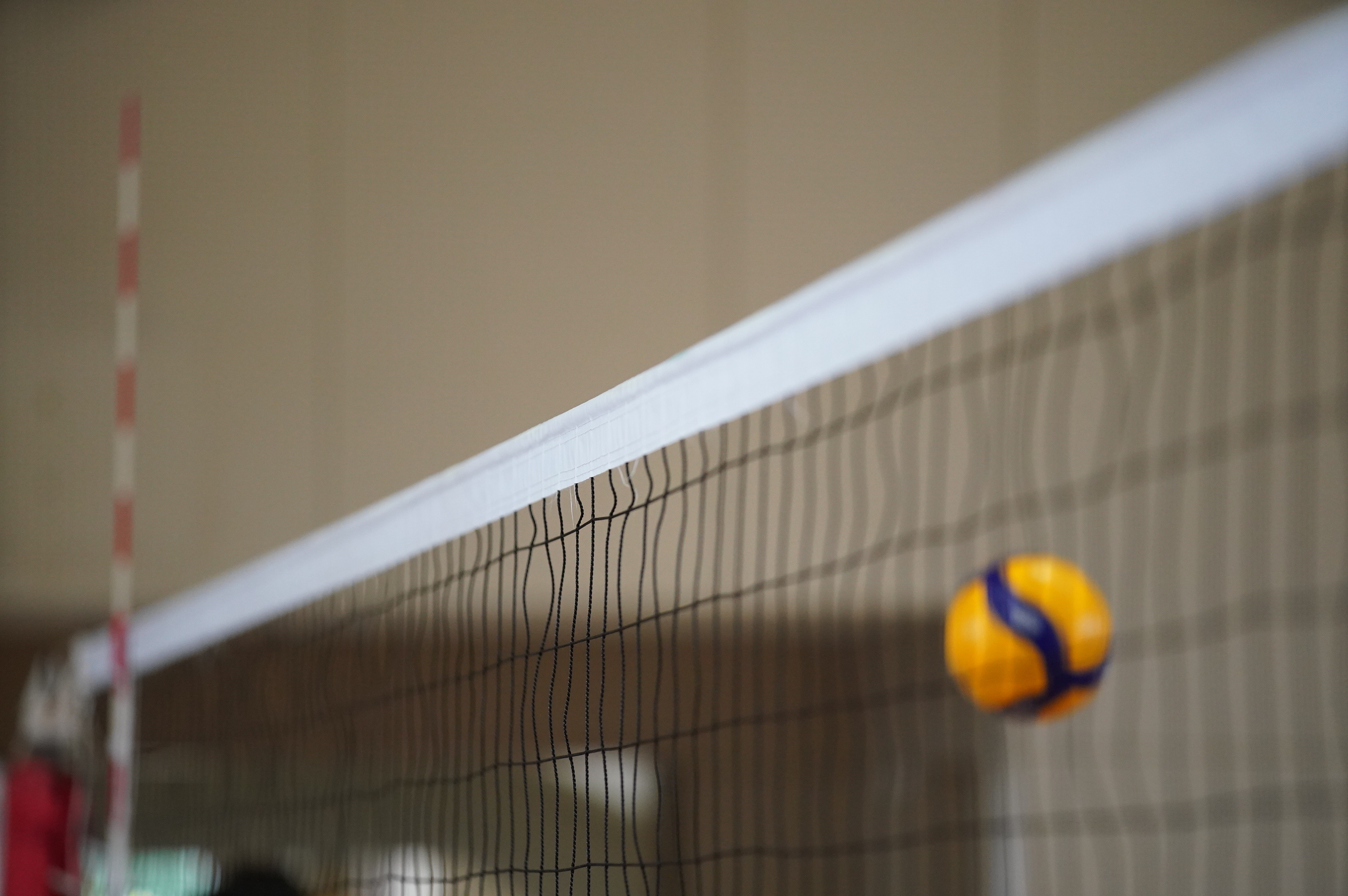 a volleyball hitting into a volley net
