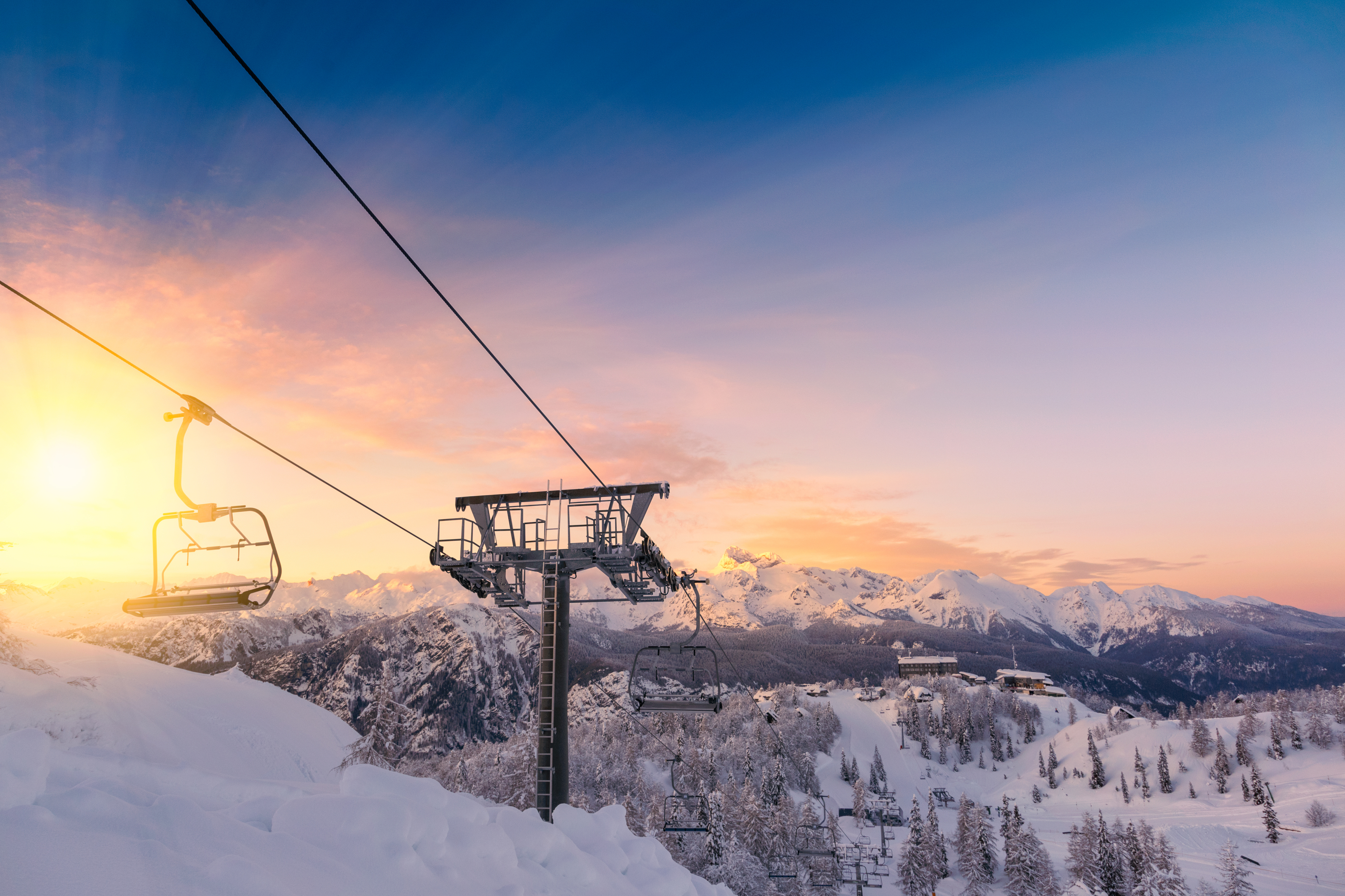 a view of the ski lifts with a beautiful sunrise behind