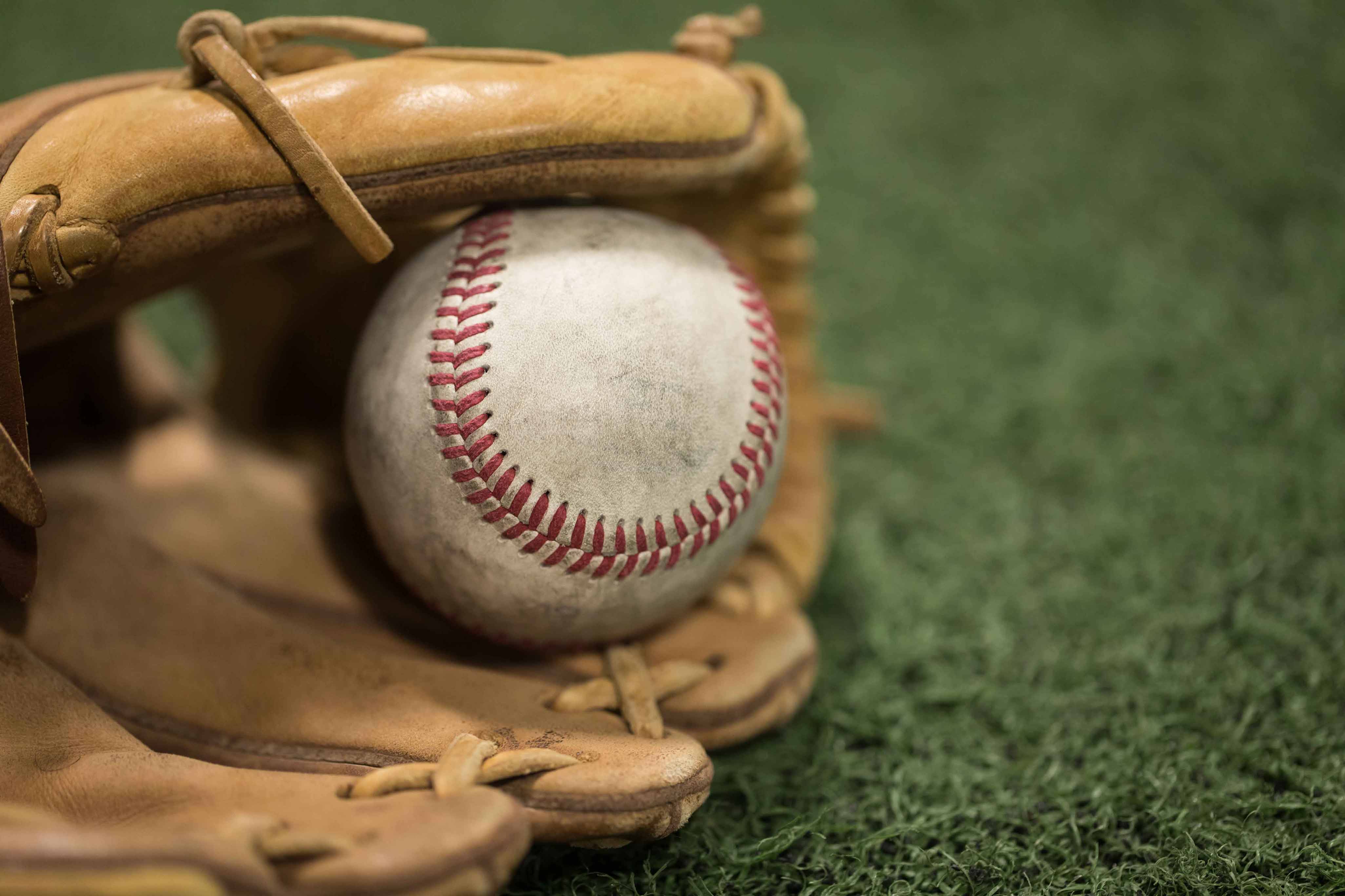 a baseball mitt on the ground holding a baseball