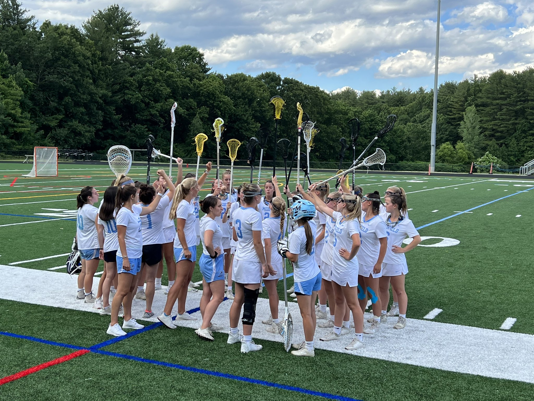 A team of Lacrosse players cheering together