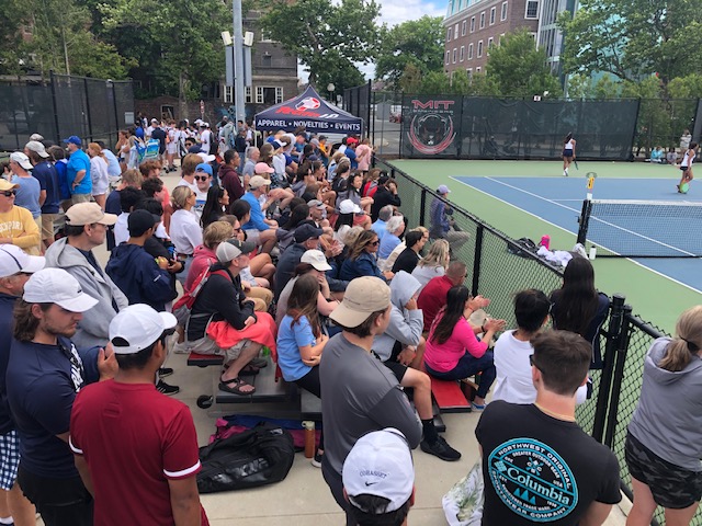 fans sitting at a tennis match in bleachers 