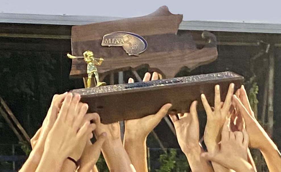 multiple peoples hands holding up a trophy
