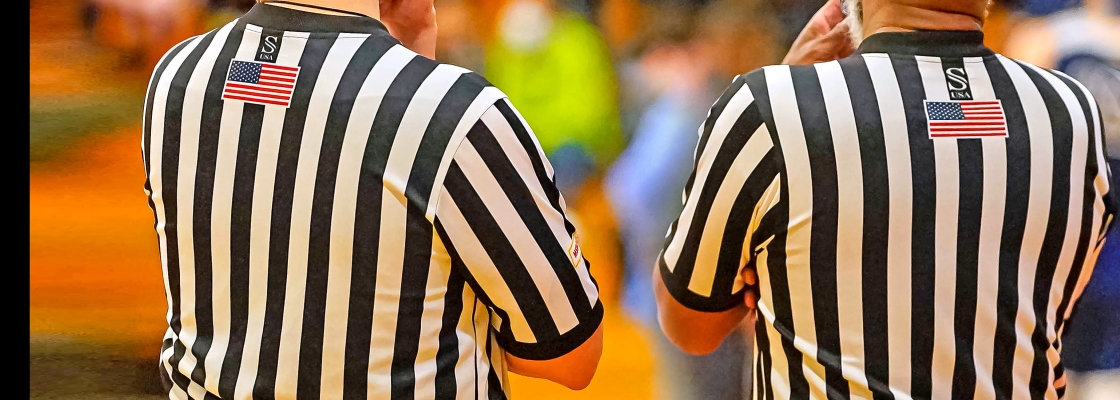 photo of the back of two referees at a game