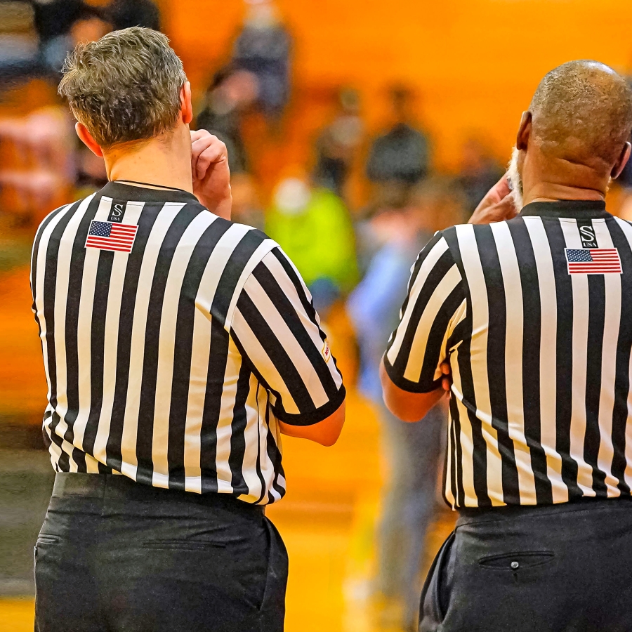 photo of the back of two referees at a game